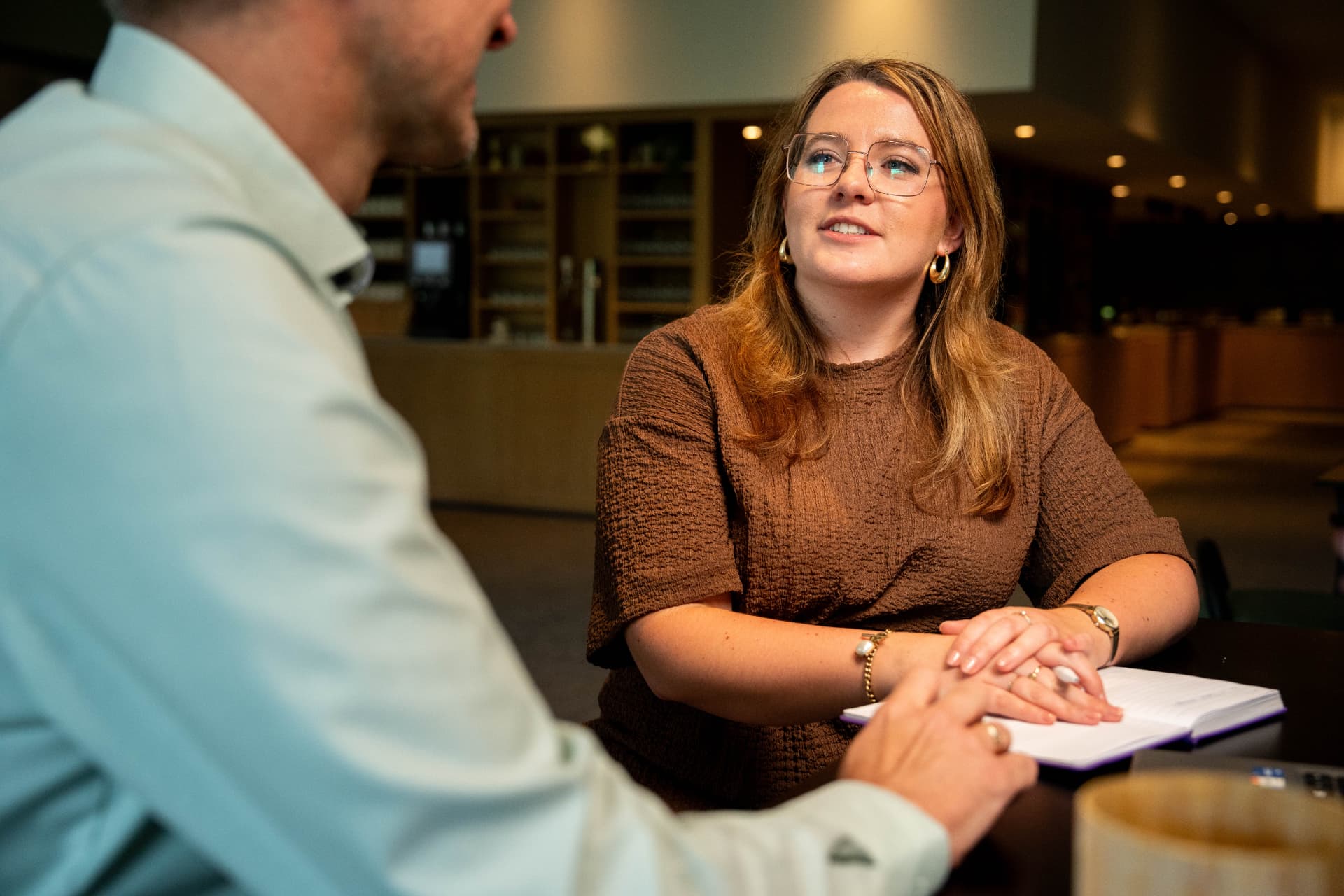 Een leidinggevende en medewerker in gesprek aan tafel