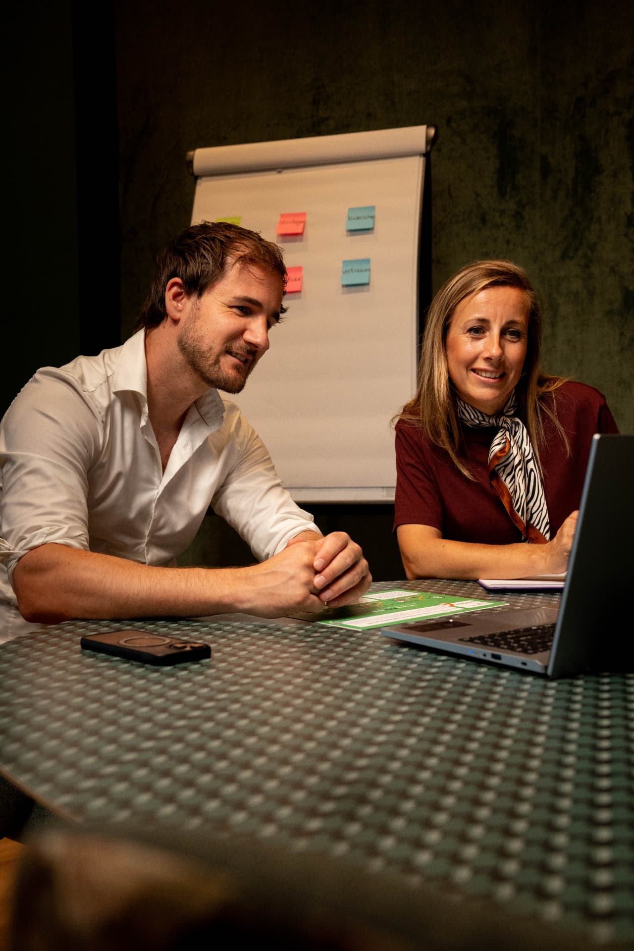Twee collega's bekijken samen het ontwikkelplan op een laptop